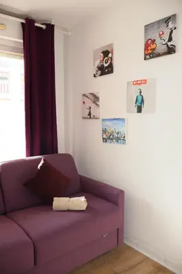 a purple couch in a room with pictures on the wall at T2 Cozy & Air-conditioned, close to All Amenities in Nice