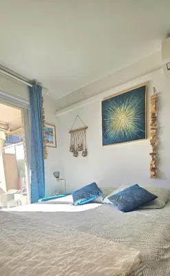 a bedroom with a bed with two blue pillows on it at T2 Cozy & Air-conditioned, close to All Amenities in Nice