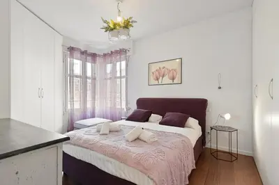 a bedroom with a large bed with a pink blanket at Suite Lycka FSHH in Nice
