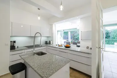a kitchen with white cabinets and a granite counter top at VILLA MARIE -Pool - Garden-Close To Beach -Parking in Nice