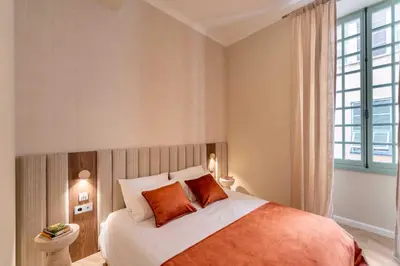 a bedroom with a bed with orange pillows and a window at 2BDR 6P central A C apt - heart of Nice in Nice