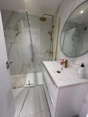 a white bathroom with a sink and a mirror at Appartement T3 NICE Promenade des Anglais in Nice