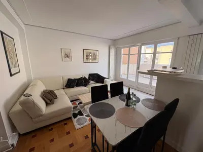 a living room with a couch and a table at Appartement T3 NICE Promenade des Anglais in Nice