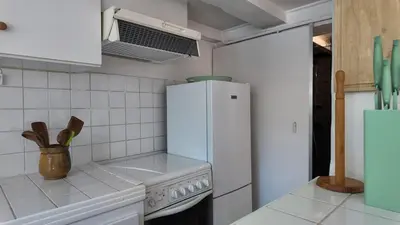 a kitchen with a white refrigerator and a stove at Studio climatisé cosy dans une villa avec parking in Cagnes-sur-Mer