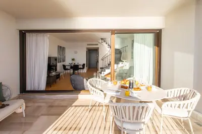 a dining room with a white table and chairs at Satywizus #22- Duplex panoramic sea view 2Bdr, AC, swimpool, parking, petanque in Nice