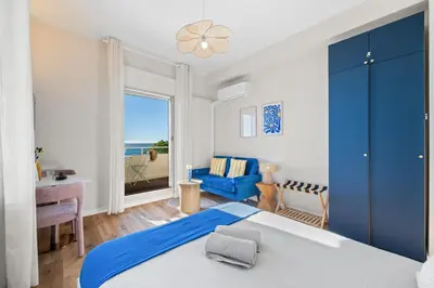 a bedroom with a blue bed and a blue chair at Vue mer panoramique - Cocon cosy et luxe - Clim et Wifi in Cagnes-sur-Mer