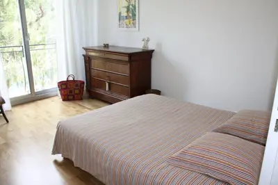 a bedroom with a bed and a dresser and a window at 4 chambres, vue mer, calme in Nice