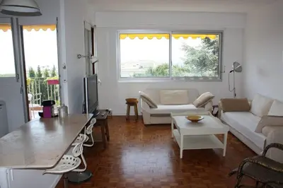a living room with a couch and a table at 4 chambres, vue mer, calme in Nice