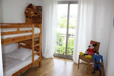 a bedroom with a bunk bed and a balcony at 4 chambres, vue mer, calme in Nice