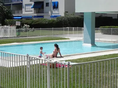 a woman and a child playing in a swimming pool at 4 chambres, vue mer, calme in Nice