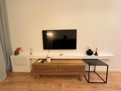 a living room with a tv on a white wall at Charmant studio climatisé à Riquier, proche mer & gare in Nice