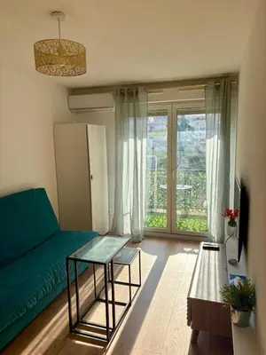 a living room with a couch and a table at Charmant studio climatisé à Riquier, proche mer & gare in Nice