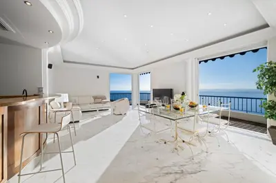 a dining room and living room with a view of the ocean at Vue exceptionnelle in Nice