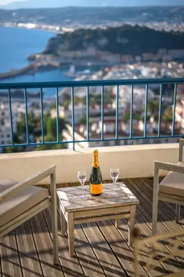 a bottle of wine on a table with two glasses on a balcony at Vue exceptionnelle in Nice