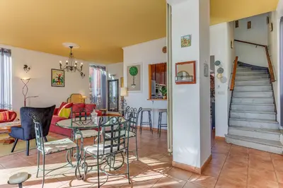 a living room and dining room with a table and chairs at VILLA BELLA VISTA BAY VI4488 By Riviera Holiday Homes in Villefranche-sur-Mer