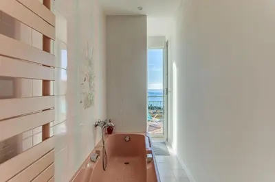 a bathroom with a pink tub and a window at VILLA BELLA VISTA BAY VI4488 By Riviera Holiday Homes in Villefranche-sur-Mer