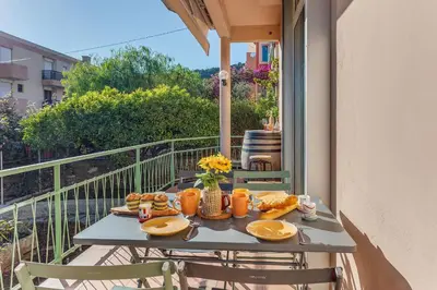 a table on a balcony with food on it at VILLA BELLA VISTA BAY VI4488 By Riviera Holiday Homes in Villefranche-sur-Mer