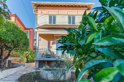 a building with a balcony and trees in front of it at VILLA BELLA VISTA BAY VI4488 By Riviera Holiday Homes in Villefranche-sur-Mer