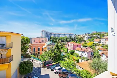 a city with cars parked in a parking lot at Espace Anahit 2 piece meublé avec balcon, proche Tram Magnan et plages BAIL MOBILITE in Nice