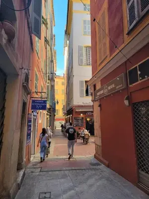 a group of people walking down a street with buildings at Sunny Old Town Studio in Nice