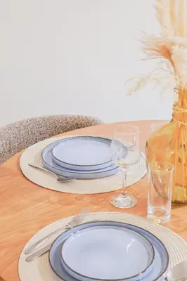 a table with blue and white plates and glasses on it at Superbe T3 tout confort à deux pas du tram et des plages in Nice