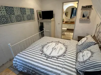 a bedroom with a bed with a striped blanket at Auberge de la Croix du Pape in Èze