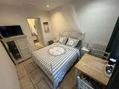 a bedroom with a bed and a table and a television at Auberge de la Croix du Pape in Èze