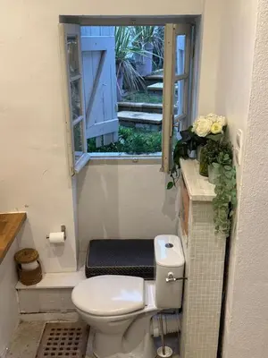 a bathroom with a toilet and a window at Auberge de la Croix du Pape in Èze