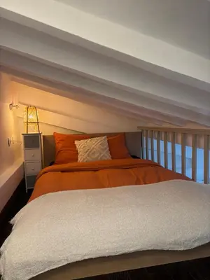 a bed with orange pillows in a bedroom at Le Saint François - Au cœur du Vieux Nice in Nice
