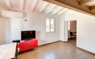 a living room with a tv on a red dresser at Le Saint François - Au cœur du Vieux Nice in Nice