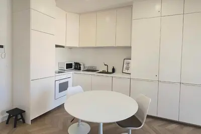 a white kitchen with a white table and chairs at appartement moderne pour 3 pers Hyper Centre proche Jean Médecin in Nice
