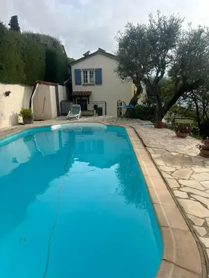 a large blue swimming pool in front of a house at Maison de charme piscine vue mer in Èze