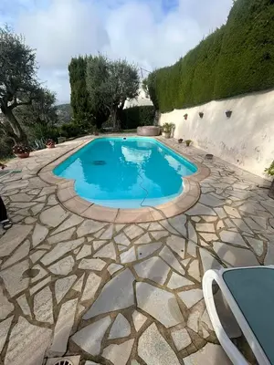 a swimming pool in a patio with a stone floor at Maison de charme piscine vue mer in Èze