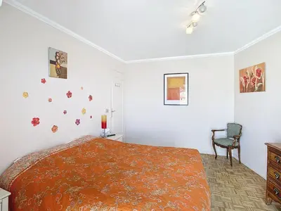 a white bedroom with a bed and a chair at Penthouse d'exception avec terrasse panoramique in Nice