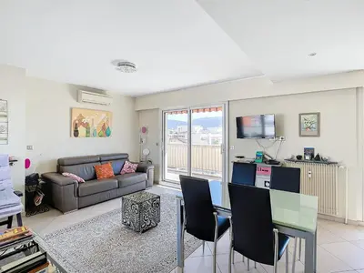 a living room with a couch and a table at Penthouse d'exception avec terrasse panoramique in Nice
