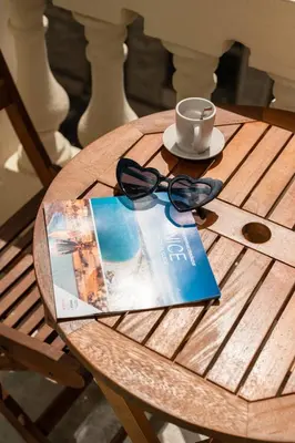 a wooden table with a cup and a pair of glasses at Magnifique - 2 chambres - Cœur de Nice avec Balcon in Nice