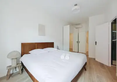 a bedroom with a large white bed with white pillows at Élégance & confort au cœur du Vieux Nice in Nice