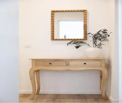 a wooden console table with a mirror on a wall at Élégance & confort au cœur du Vieux Nice in Nice