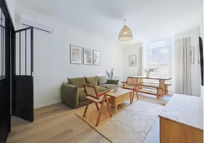 a living room with a couch and a table at Élégance & confort au cœur du Vieux Nice in Nice
