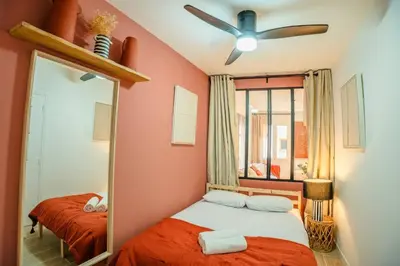 a bedroom with a bed with a mirror and a ceiling fan at Splendide Appartement Rénové Au Cœur du Vieux Nice in Nice