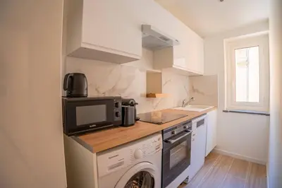 a kitchen with a washing machine and a microwave at Splendide Appartement Rénové Au Cœur du Vieux Nice in Nice