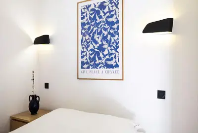 a bedroom with a blue and white picture on the wall at Moderne et lumineux en centre-ville - 2 Chambres in Nice
