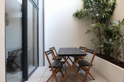 a table and chairs on a balcony with plants at Nümad Suites in Nice