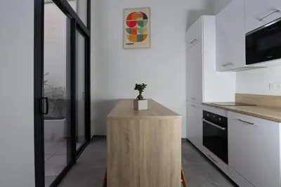 a kitchen with a wooden island with a plant on it at Nümad Suites in Nice