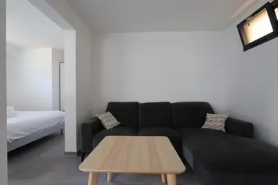 a living room with a black couch and a table at Nümad Suites in Nice