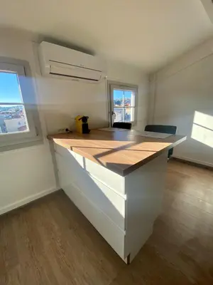a kitchen with a white counter top with two windows at Studio moderne au Carré d'Or in Nice