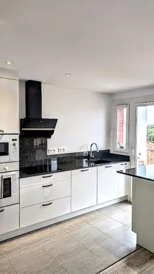 a kitchen with white cabinets and a black counter top at PANORAMIC SEA VIEW with PRIVATE PARKING and AC in Nice