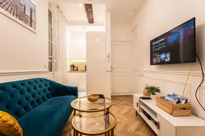 a living room with a blue couch and a tv at La Bellanda - Au coeur du Vieux Nice in Nice