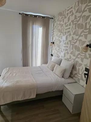 a bedroom with a white bed and a window at La costière in Nice