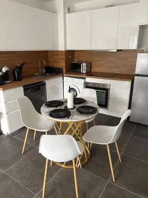 a kitchen with a table and chairs in a kitchen at Le Bonappart T3 Grande Terrasse in Nice